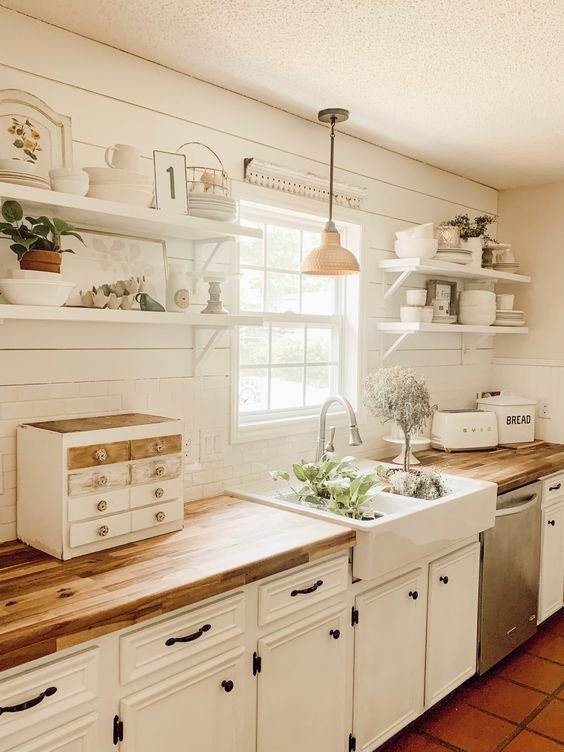 A farmhouse-style kitchen in a tiny house with pendant lighting over the counter.